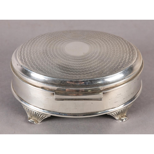 259 - A GEORGE V SILVER JEWELLERY BOX, engine turned hinged top of oval outline, with four tapered and ree... 