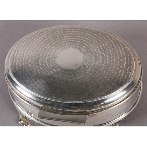 259 - A GEORGE V SILVER JEWELLERY BOX, engine turned hinged top of oval outline, with four tapered and ree... 