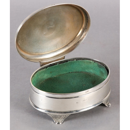 259 - A GEORGE V SILVER JEWELLERY BOX, engine turned hinged top of oval outline, with four tapered and ree... 