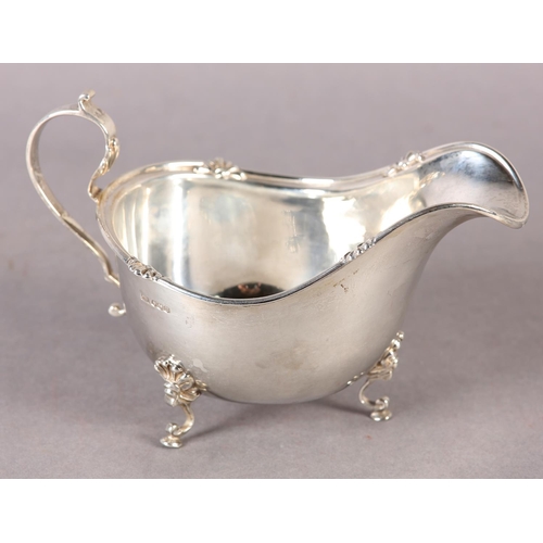 260 - A GEORGE V SILVER SAUCE BOAT with C scroll handle and acanthus rim, on three pad feet, Sheffield 192... 