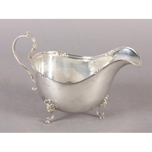 260 - A GEORGE V SILVER SAUCE BOAT with C scroll handle and acanthus rim, on three pad feet, Sheffield 192... 