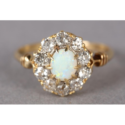 320 - AN EDWARD VII OPAL AND DIAMOND CLUSTER RING in 18ct gold, the oval cabochon stone claw set within a ... 