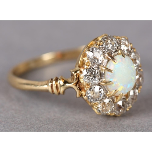 320 - AN EDWARD VII OPAL AND DIAMOND CLUSTER RING in 18ct gold, the oval cabochon stone claw set within a ... 