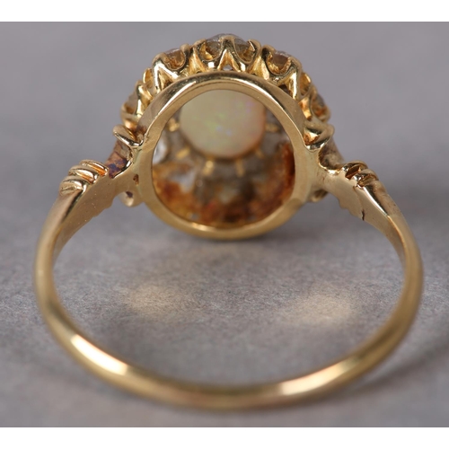 320 - AN EDWARD VII OPAL AND DIAMOND CLUSTER RING in 18ct gold, the oval cabochon stone claw set within a ... 