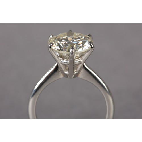 290 - A SINGLE STONE DIAMOND RING IN PLATINUM, the certified brilliant cut stone claw set and raised again... 