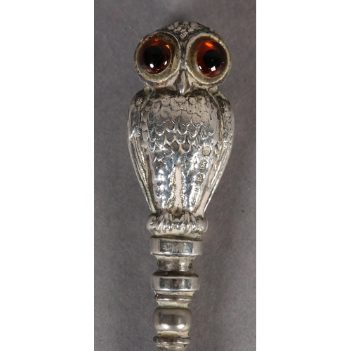 274 - A VICTORIAN SILVER OWL BUTTON HOOK, the double-sided handle as an owl with brown and blue glass eyes... 