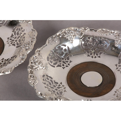 202 - A PAIR OF VICTORIAN SILVER COASTERS, Sheffield 1868, of basket style with pierced panels, below a fr... 