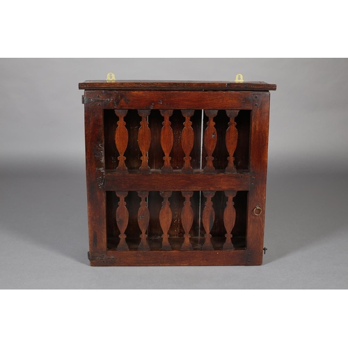 467 - AN 18TH CENTURY OAK HANGING LIVERY CUPBOARD, the single door pierced with two rows of spindle forms,... 