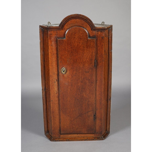 472 - A MID 18TH CENTURY OAK HANGING CORNER CUPBOARD, of arched profile with moulded cornice and sides, ab... 