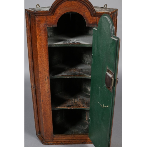 472 - A MID 18TH CENTURY OAK HANGING CORNER CUPBOARD, of arched profile with moulded cornice and sides, ab... 