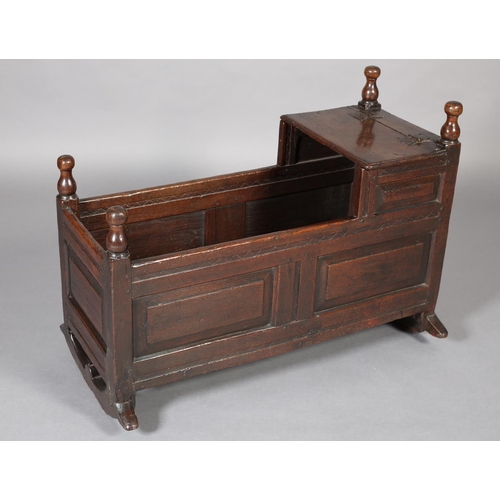 471 - A MID 18TH CENTURY OAK CRADLE, having a square canopy with hinged top, field panelled to all sides, ... 