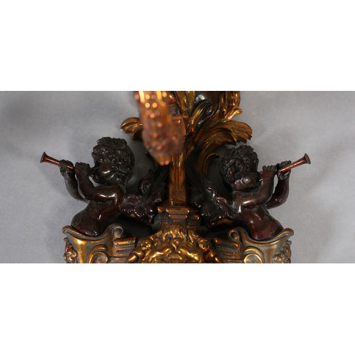 70 - A PAIR OF GILT AND BRONZED METAL TRIPLE LIGHT WALL SCONES, cast as a crowned orb above a shield moun... 