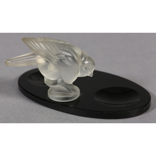 177B - A FRENCH MOULDED OPAQUE GLASS BIRD, mounted on a black glass desk tidy of oval outline, c.1930s, 17.... 