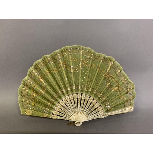 32 - An elegant c 1905 fan in ballon form, the monture shaped, incised and gilded, the olive-green silk l... 