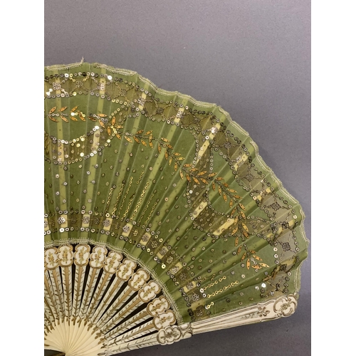 32 - An elegant c 1905 fan in ballon form, the monture shaped, incised and gilded, the olive-green silk l... 