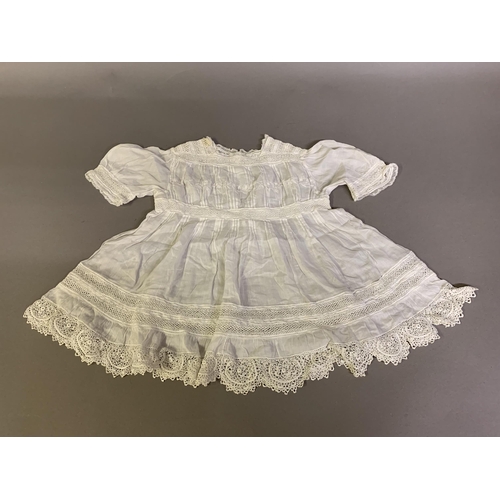 174 - A small Edwardian child’s lawn and crochet dress, white embroidery to the bodice, waist panel approx... 