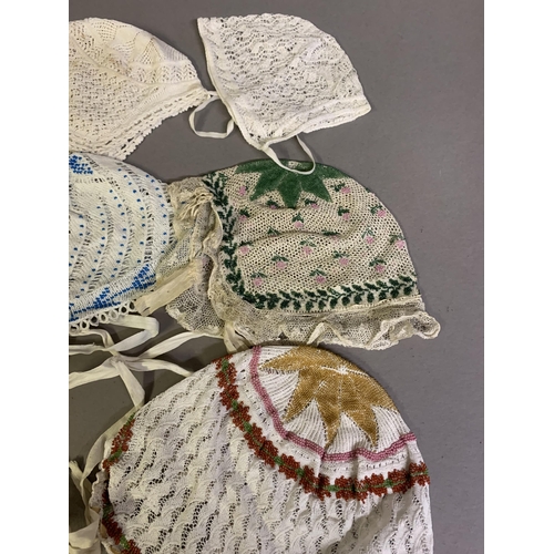 173 - Eight European lace bonnets, mainly 19th century and mainly knitted, four incorporating tiny beads i... 