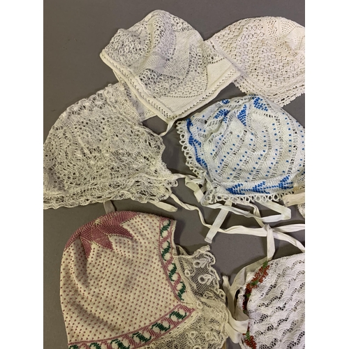 173 - Eight European lace bonnets, mainly 19th century and mainly knitted, four incorporating tiny beads i... 