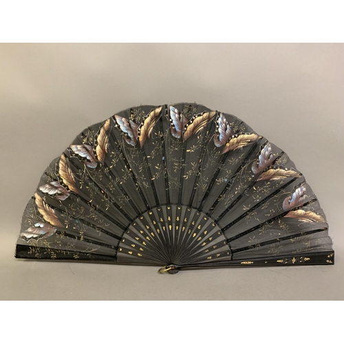 12 - Three large c 1890’s fans, all on black wood, the first with a deep border of painted butterflies, f... 