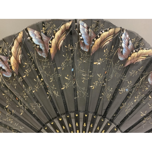 12 - Three large c 1890’s fans, all on black wood, the first with a deep border of painted butterflies, f... 