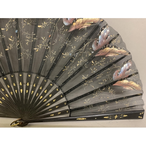 12 - Three large c 1890’s fans, all on black wood, the first with a deep border of painted butterflies, f... 