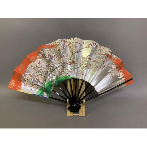 142 - Twentieth century Chinese and Japanese fans: a large folding paper fan, the plain wood sticks with w... 