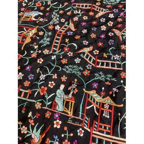 273 - A Chinese canton embroidered shawl, black silk embroidered in many colours, featuring garden scenes ... 