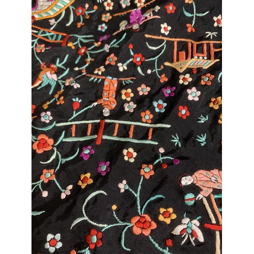 273 - A Chinese canton embroidered shawl, black silk embroidered in many colours, featuring garden scenes ... 