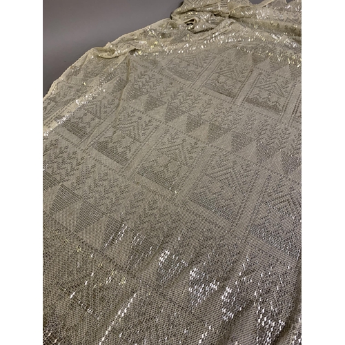 271 - 1920’s, a wide cream azute or assuit shawl, the pressed silver decoration in multiple bands of styli... 