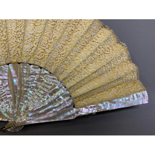 80 - A 19th century pink mother of pearl fan with bobbin and earlier needle lace leaf, the lace laid over... 