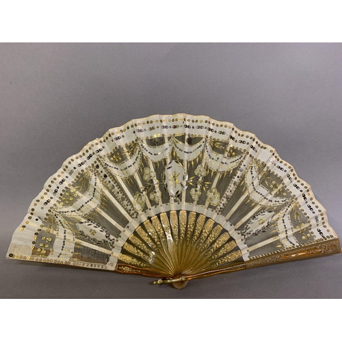 46 - Two fans C 1900/1910, the first a small gold sequin fan, the leaf of gold lamé overlaid with cream s... 