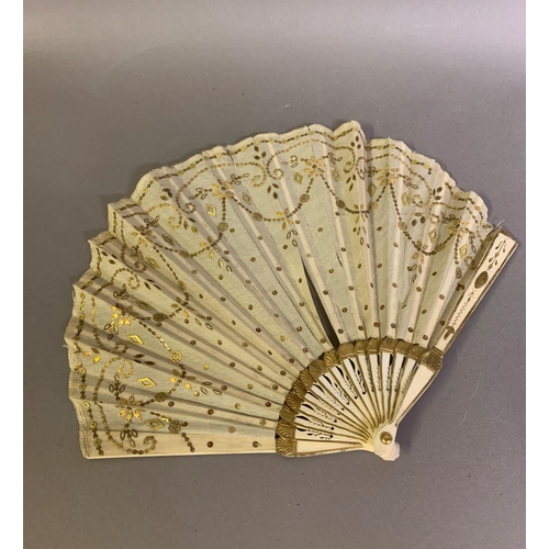 46 - Two fans C 1900/1910, the first a small gold sequin fan, the leaf of gold lamé overlaid with cream s... 