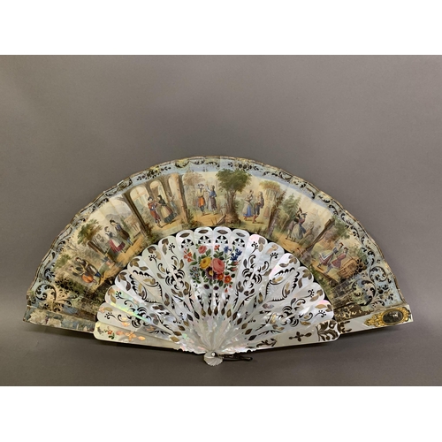 49 - A large and showy mother of pearl fan, the wide sticks gilded and brightly painted with flowers, pie... 