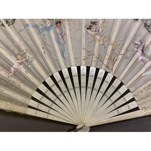 50 - c1890s, a large incised bone fan, the cream silk leaf painted with winged cherubs carrying fruits an... 