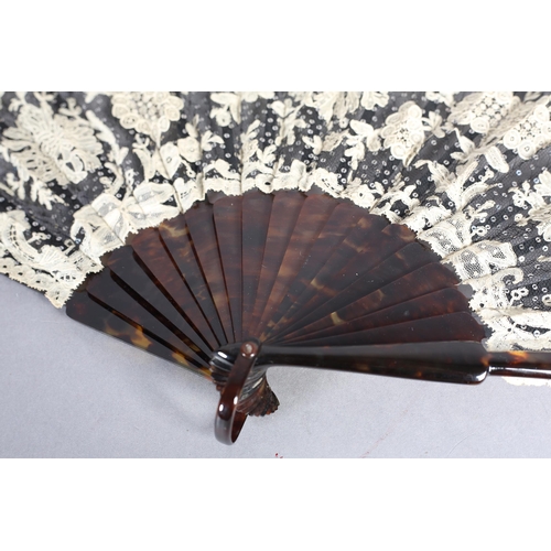 85 - c1905, a black net and mixed Brussels lace fan, the unusual needle lace floral motifs applied to bla... 