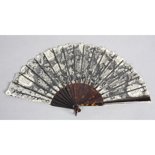 85 - c1905, a black net and mixed Brussels lace fan, the unusual needle lace floral motifs applied to bla... 