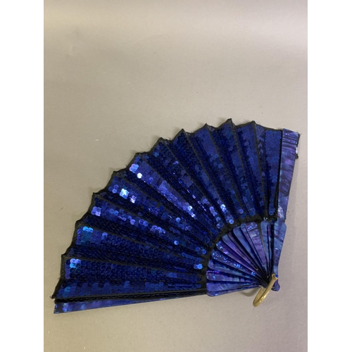 61 - An early 20th century opera fan, the leaf a panel of black gauze covered with bright blue sequins, w... 