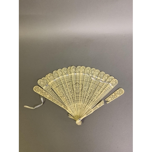 65 - A mid-19th century bone fan, the monture lightly carved and pierced, the lithographed leaf showing a... 