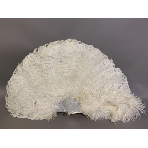 108B - A cream ostrich feather fan mounted on white mother pf pearl with a hint of pink; together with a si... 