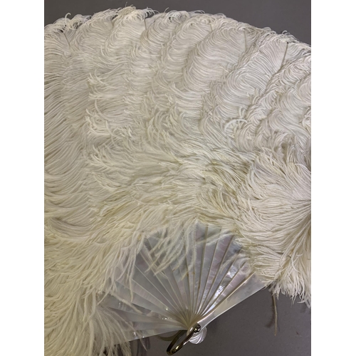 108B - A cream ostrich feather fan mounted on white mother pf pearl with a hint of pink; together with a si... 