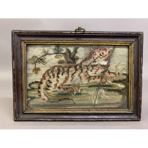 155 - A miniature, naïve woolwork picture of a recumbent tiger, worked in shades of ginger to white, alert... 