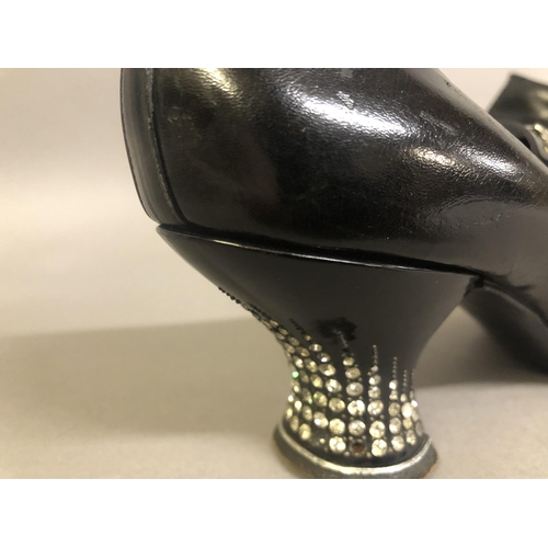 237 - Early 1920’s black leather shoes fitted with diamanté inset heels, the front bar on elastic and ador... 