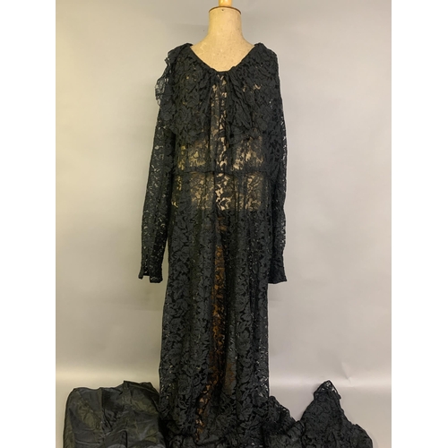 288 - A 1930’s black machine lace dress with shawl collar, long sleeves, frilled hem, with full structured... 