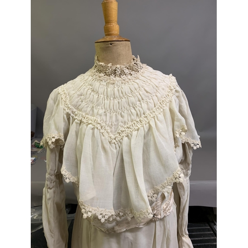 214 - A cream Edwardian two-piece costume, the high-necked bodice boned, with waist tie, an inside panel w... 