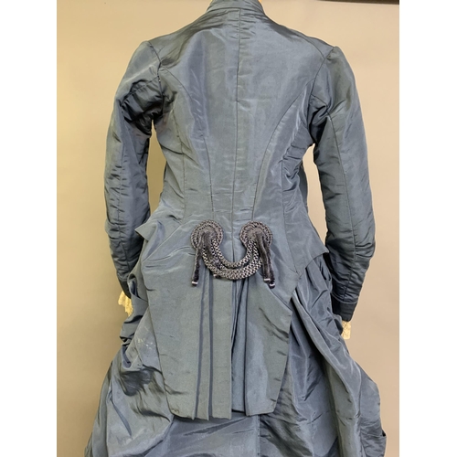 215 - A c 1880’s teal silk two-piece costume, the fitted bodice with narrow shaped sleeves, machine lace a... 