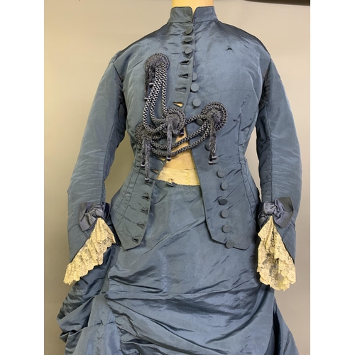 215 - A c 1880’s teal silk two-piece costume, the fitted bodice with narrow shaped sleeves, machine lace a... 