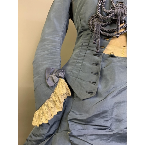 215 - A c 1880’s teal silk two-piece costume, the fitted bodice with narrow shaped sleeves, machine lace a... 