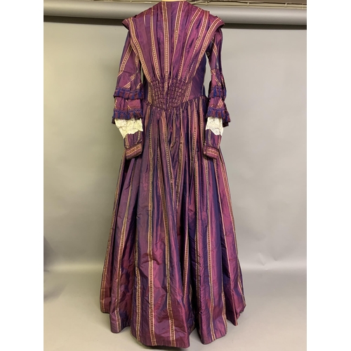 218 - A fine and unusual striped purple silk dress c 1850’s, with tiered pagoda sleeves, finished with sil... 