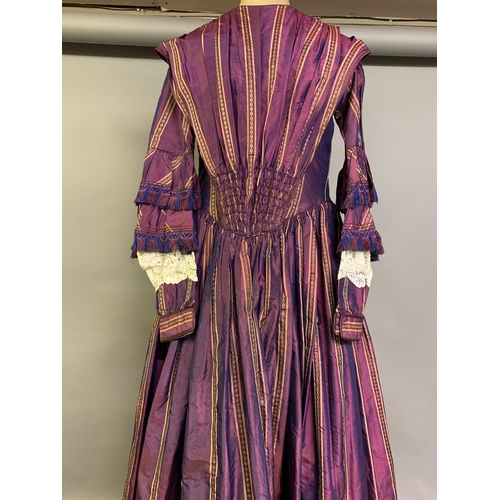 218 - A fine and unusual striped purple silk dress c 1850’s, with tiered pagoda sleeves, finished with sil... 