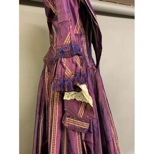 218 - A fine and unusual striped purple silk dress c 1850’s, with tiered pagoda sleeves, finished with sil... 